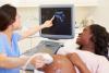 pregnant woman being shown ultrasound image of her developing baby