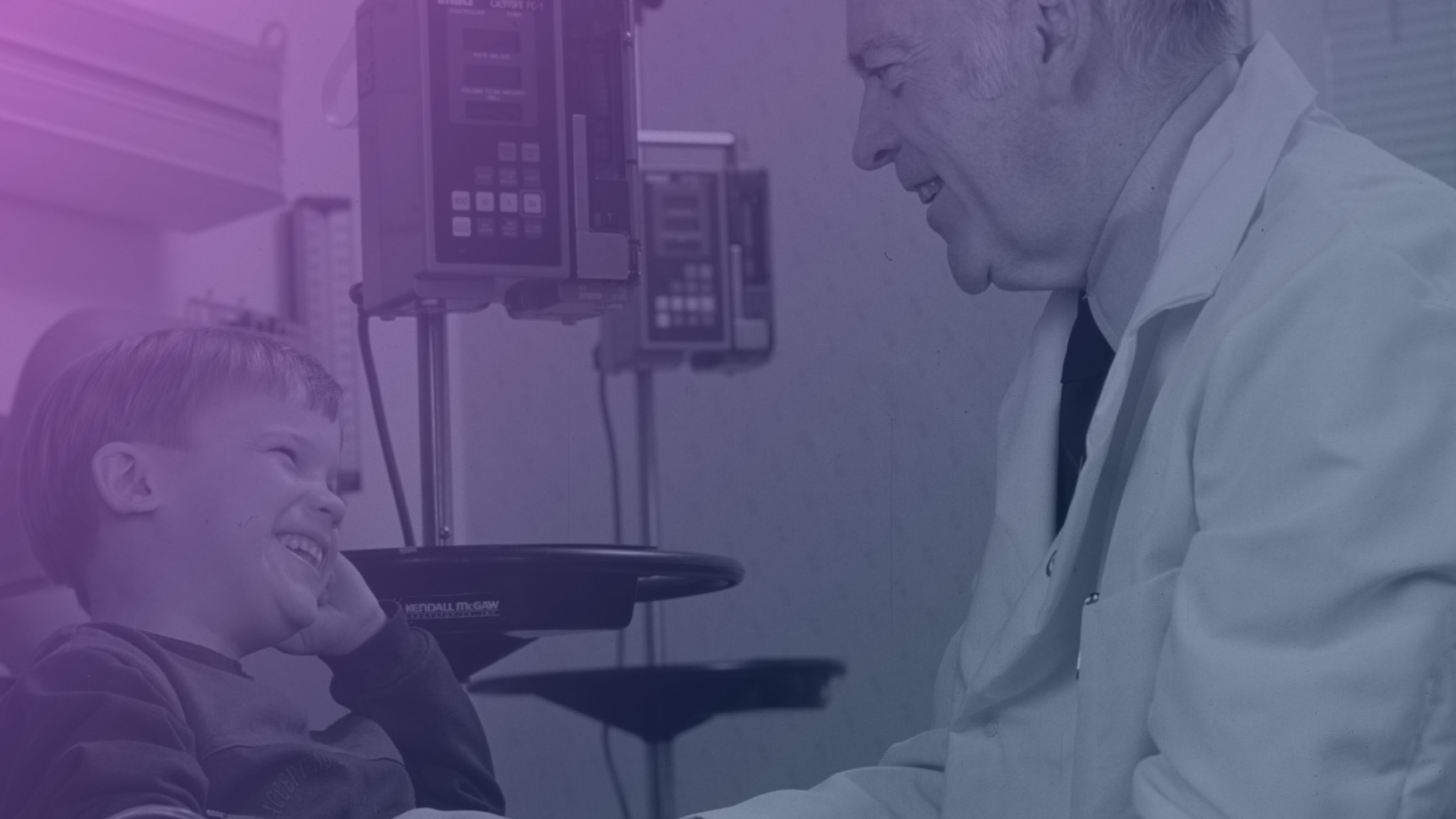 Doctor and young patient in a clinical setting, engaging in conversation and smiling warmly.