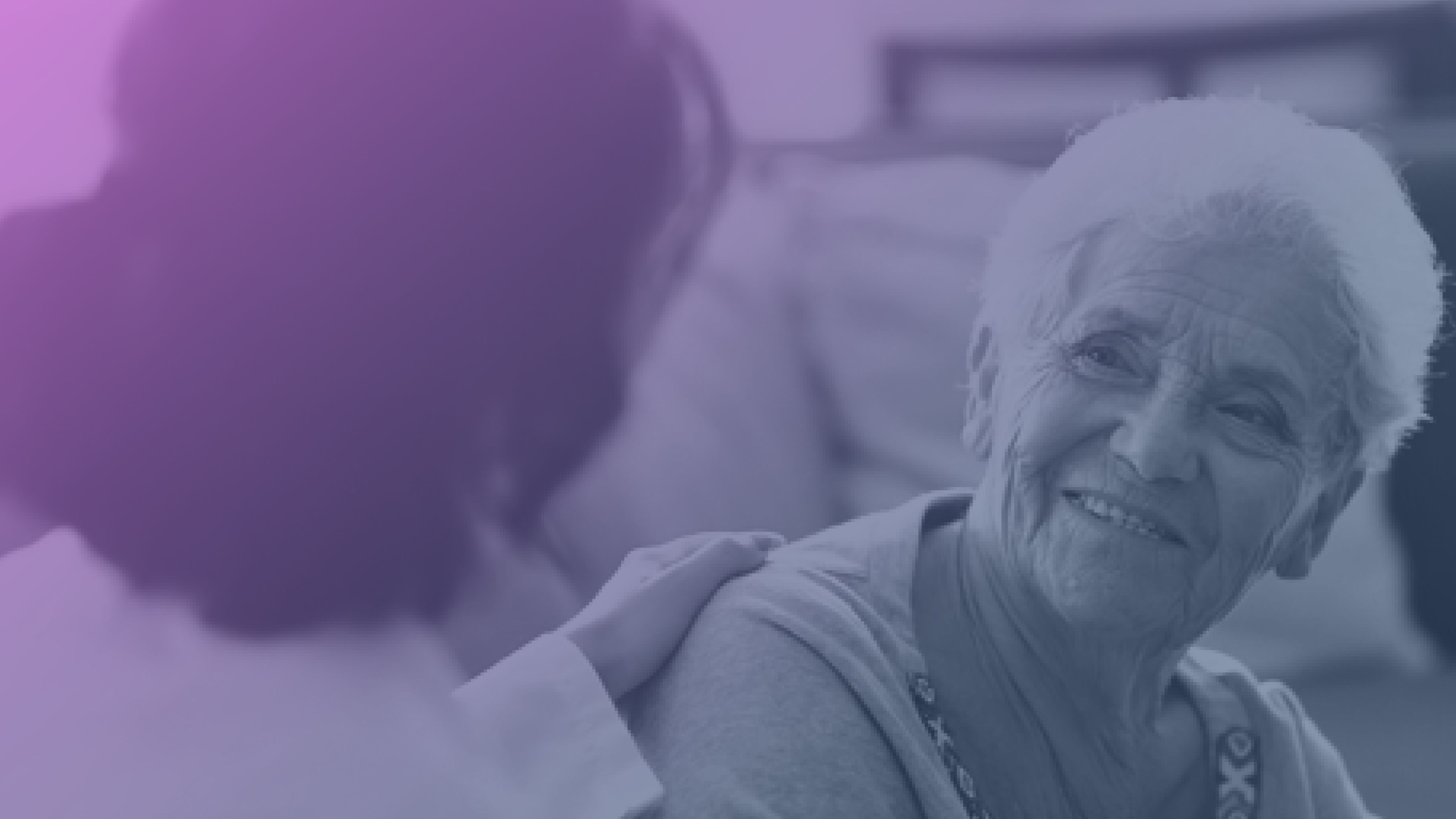 Elderly woman smiling warmly while engaging in conversation with a healthcare professional offering support.