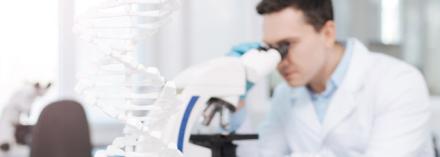 Researcher looking through microscope lense. Focus On Bioengineering ban