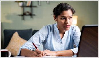 a woman looking at a screen and taking notes 