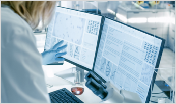 a scientist looking at 2 computer screens