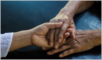 a person holding the hands of an older person