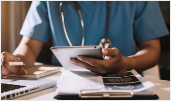 a doctor holding a tablet and using a computer