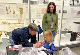 A young scout talks with volunteers about the brain.