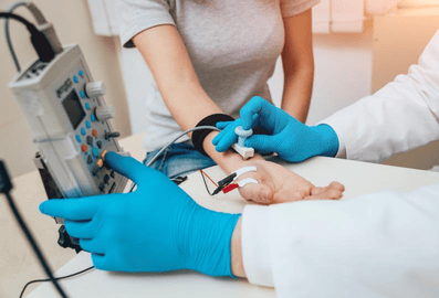 Una mujer se realiza una prueba de electromiografía (EMG), que puede diagnosticar trastornos de los nervios y músculos, compresión de raíces nerviosas espinales y trastornos de las neuronas motoras, como la esclerosis lateral amiotrófica (ELA).