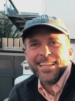 A man sporting a hat and a sweater, showcasing a casual yet trendy appearance.