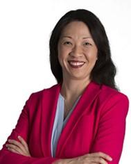 woman smiling with arms crossed with a red jacket and white top