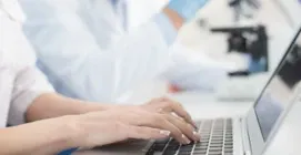 Researcher typing on laptop keyboard.