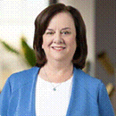 Woman in a blue blazer against a softly blurred background.