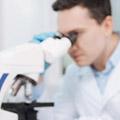 Researcher looking through microscope lense.