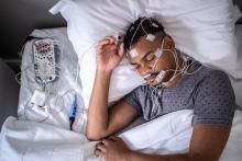 Man taking a polysomnogram test, also known as a sleep study test, which measures brain and body activity during sleep.