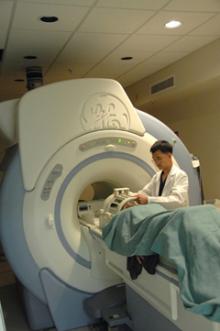 image of tech assisting patient in an MRI machine