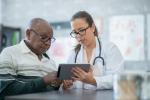 Doctor reviewing electronic tablet with patient